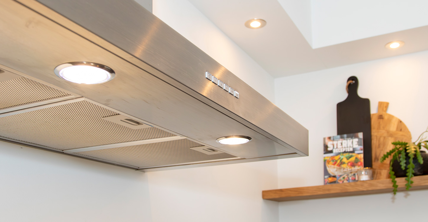 Grijze afzuigkap in moderne hoekkeuken