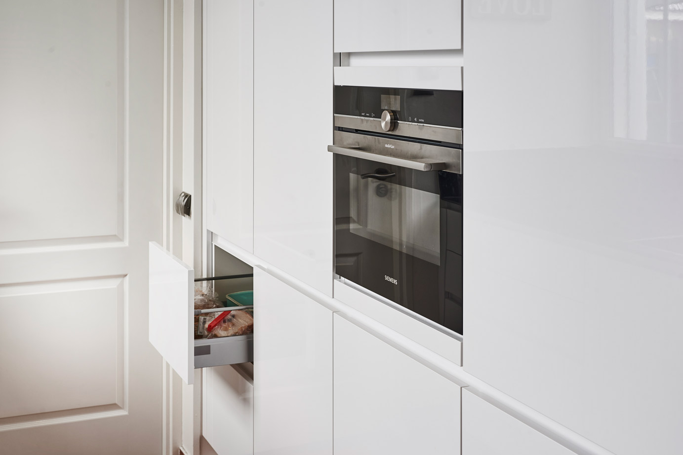 Parallelle keuken in Zeeland met greeploos front in hoogglans wit