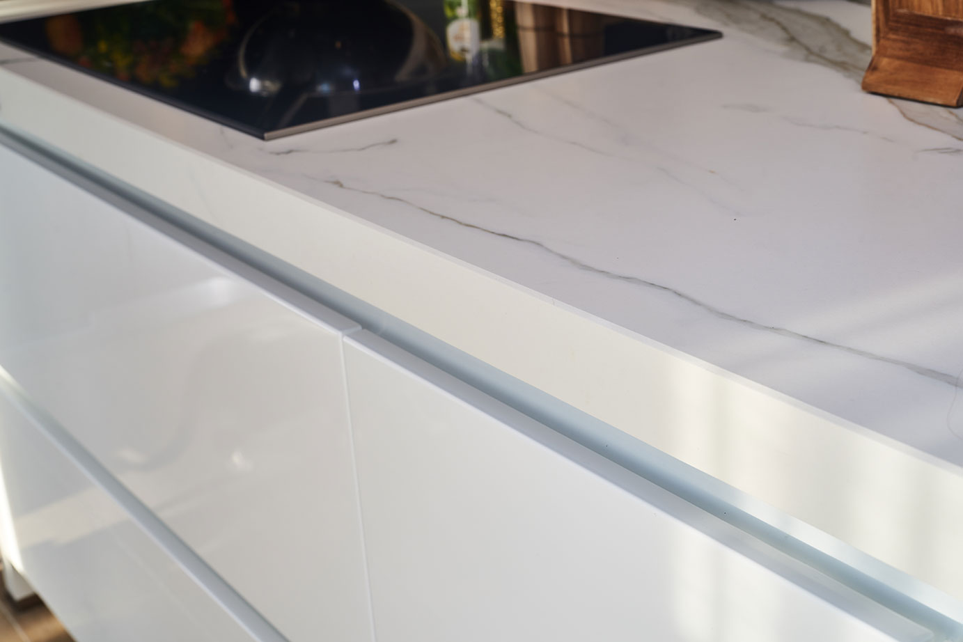 Eilandkeuken met kastenwand, aanrechtblad wit marmer, greeploos