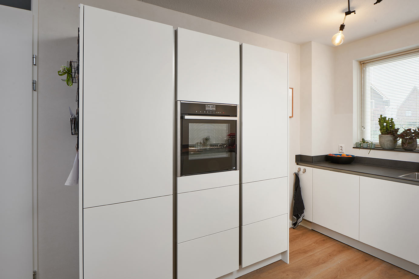 Moderne hoekkeuken Heerhugowaard, kastenwand