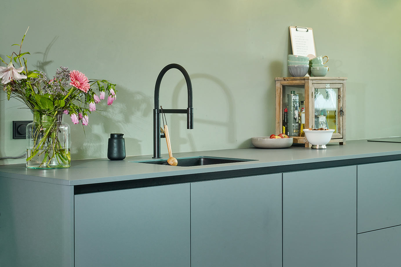 Moderne groene keuken Mijdrecht, zwarte kraan en spoelbak