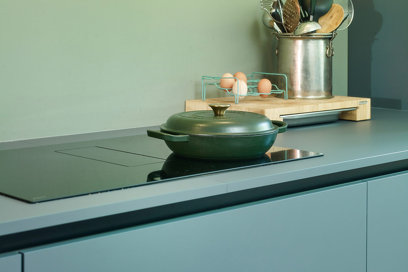 Moderne groene keuken, inductiekookplaat met afzuiging