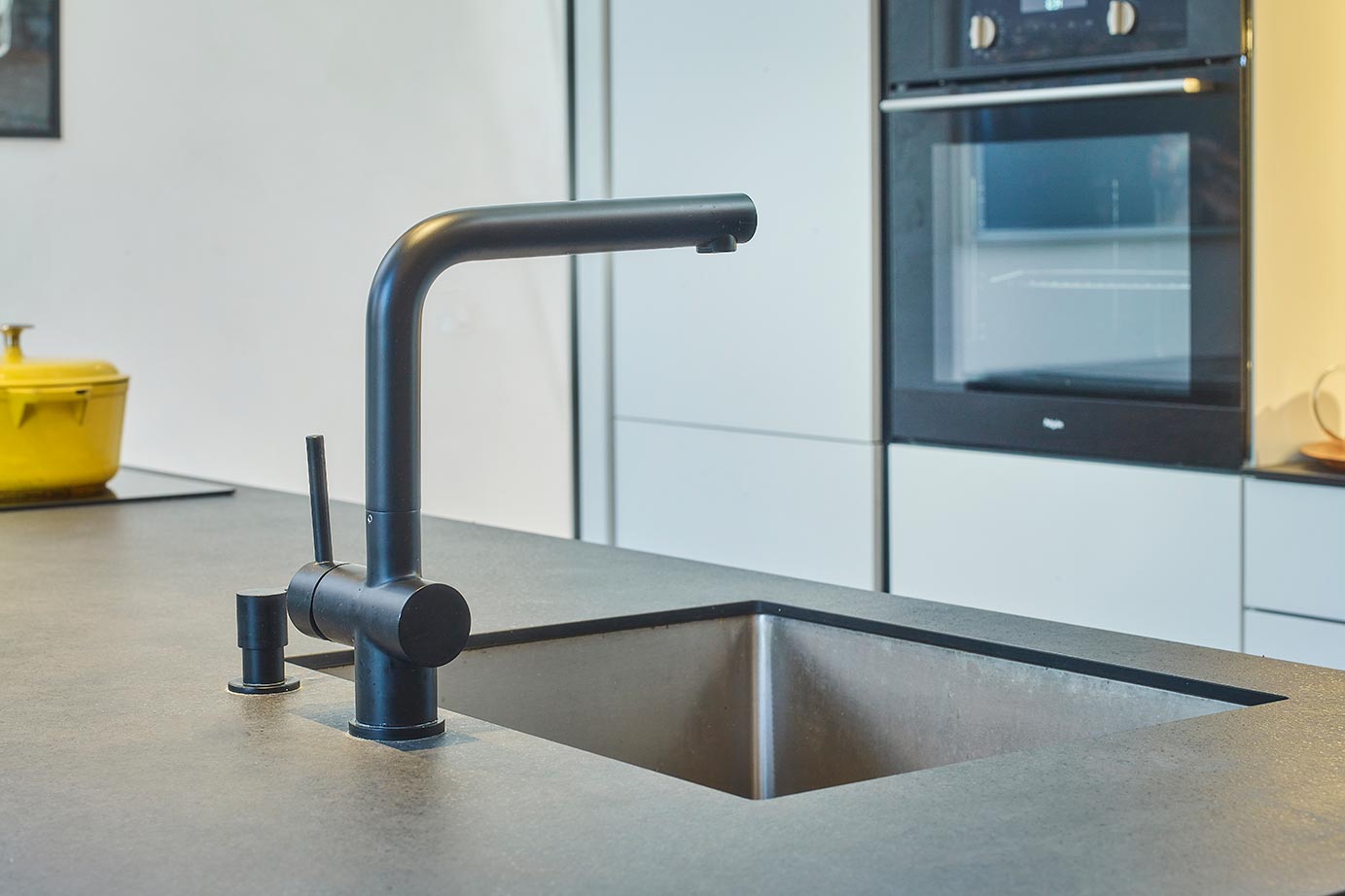 Zwarte kraan in de keuken, met betonlook keramiek aanrechtblad
