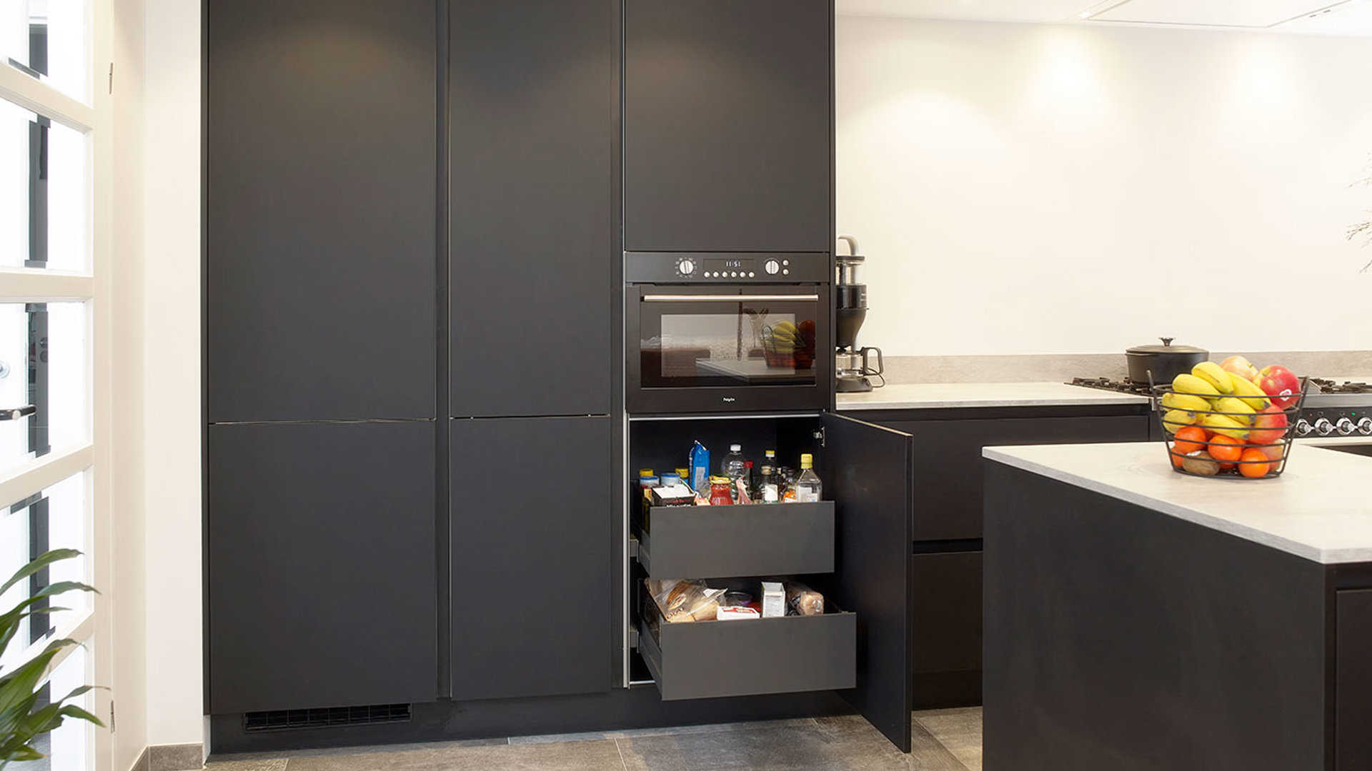 Zwarte keuken met eiland Urk, lades achter kastdeur