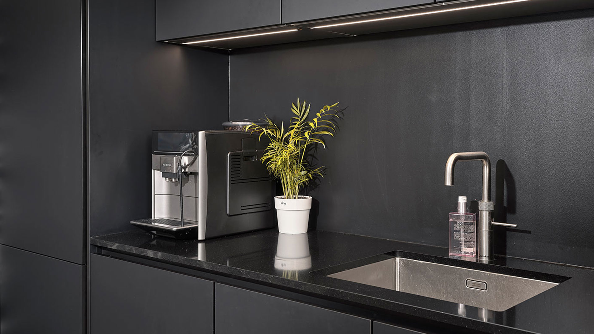 Moderne keuken Katwijk, zwarte kasten, achterwand en werkblad