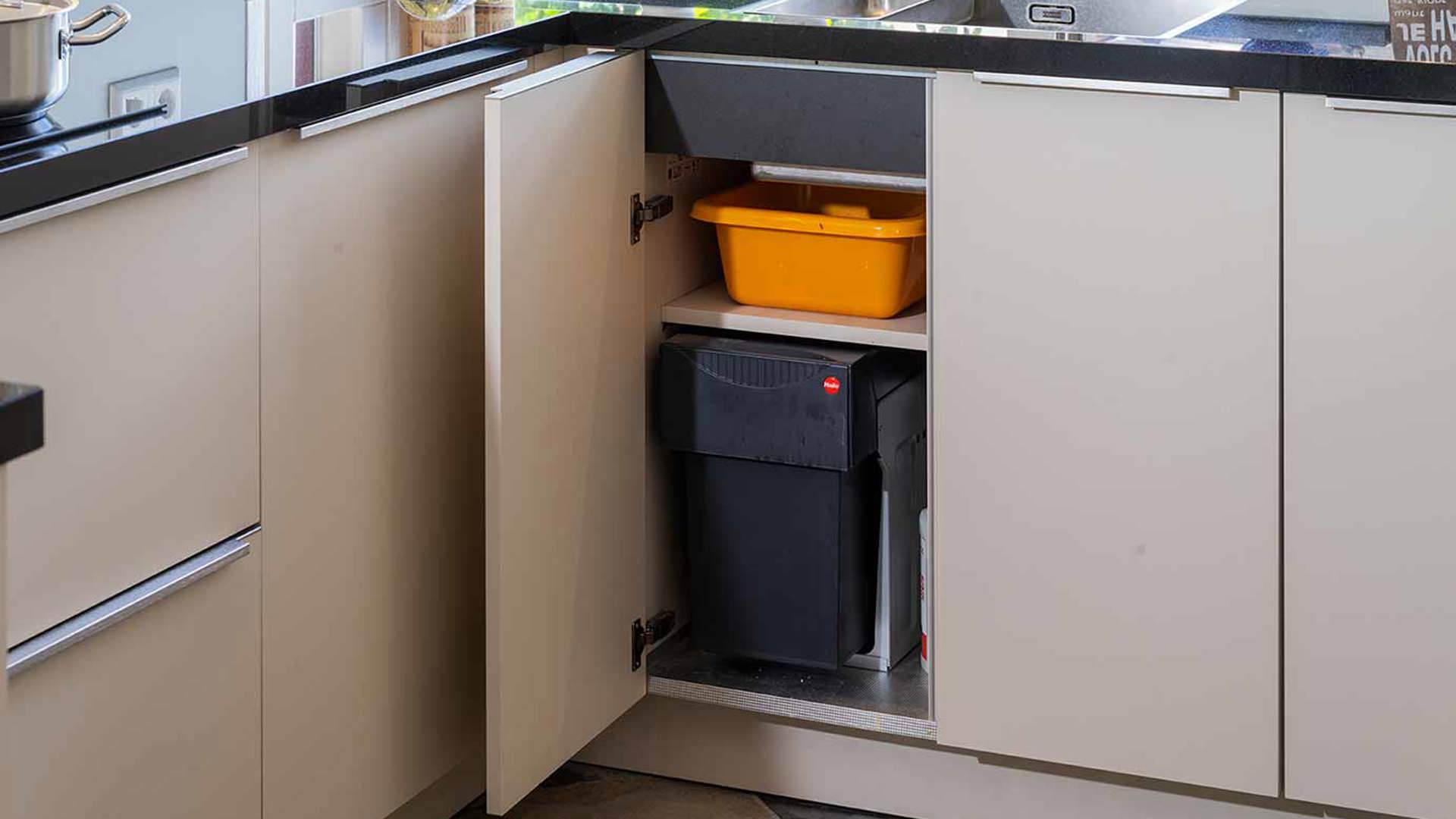 Zandkleurige keuken met weggewerkte prullenbak