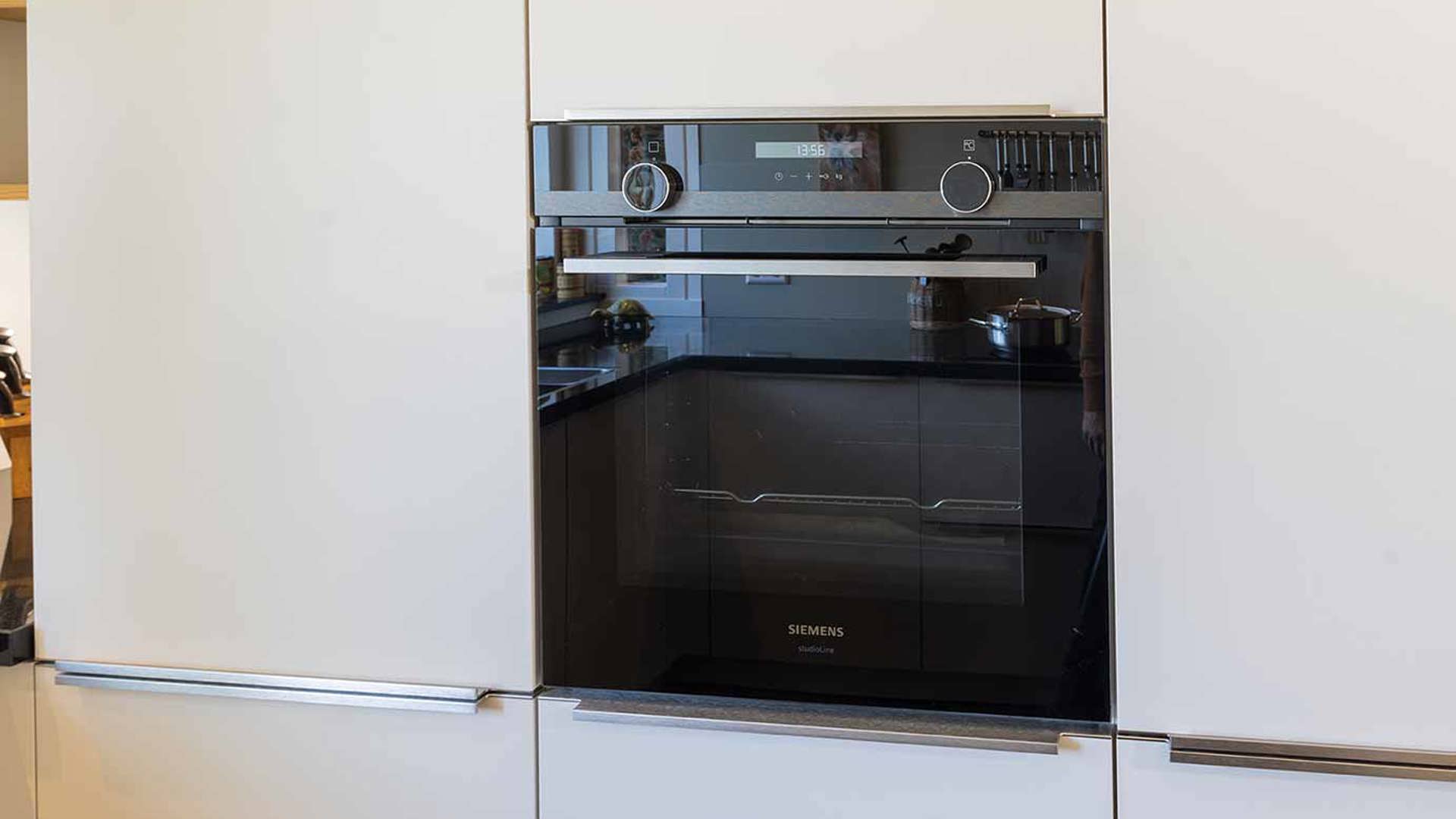 Zandkleurige G-keuken met inbouwapparatuur