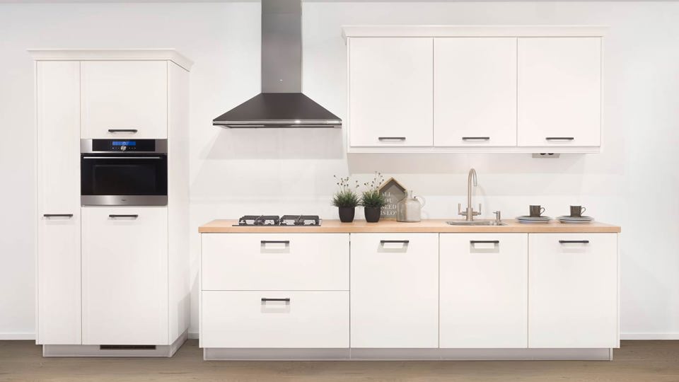 Tijdloze witte keuken met zwart kunststof aanrechtblad. 