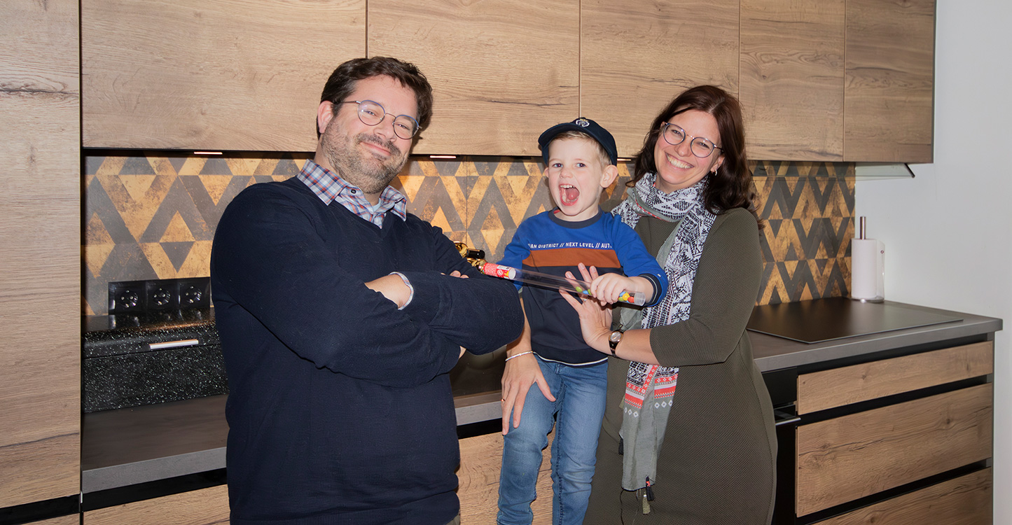 Foto van het gezin Woudt, vader moeder en zoon. Foto is voor de houten keuken genomen