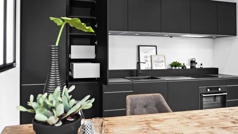 Moderne zwarte keuken in rechte opstelling
