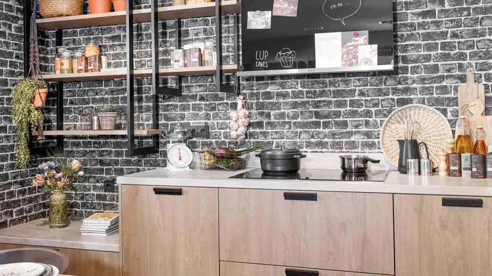 Industriële keuken met ijzeren wandrekken en betonnen aanrechtblad