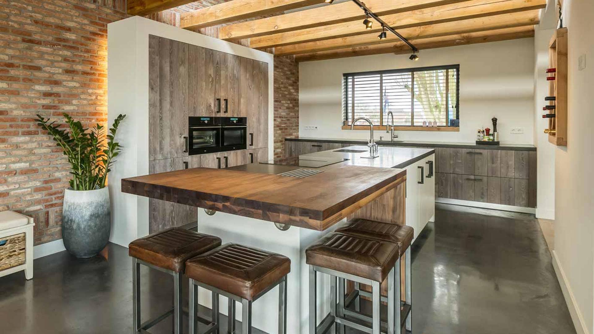 Keuken met eiland in landelijk moderne stijl met kastenwand en bar