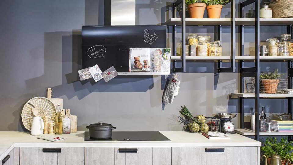 Industriële houten hoekkeuken met ijzeren wandrekken en NEFF apparatuur