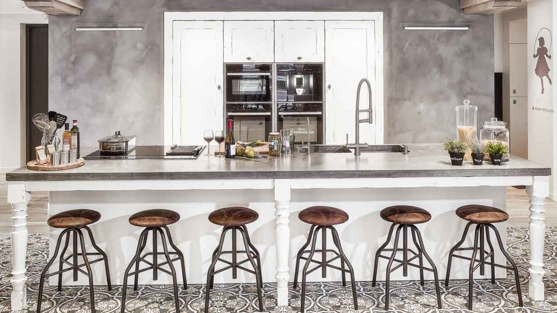 Houten landelijke maatwerkkeuken met betonnen aanrechtblad en patchwork vloertegels