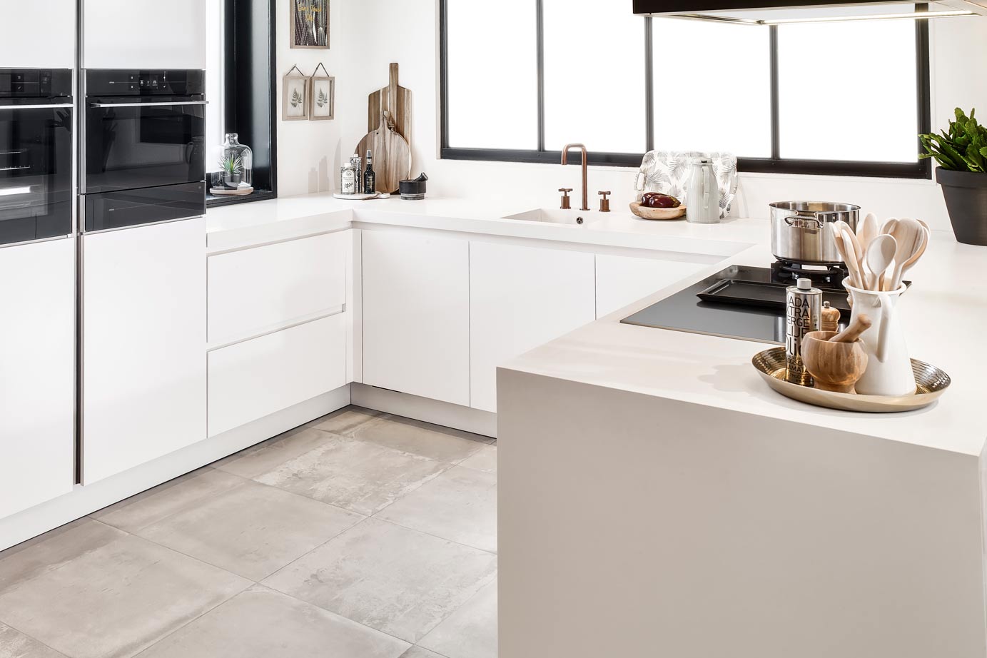 Een moderne u-keuken in de kleur mat wit, uitgevoerd in ton-sur-ton kleurstelling