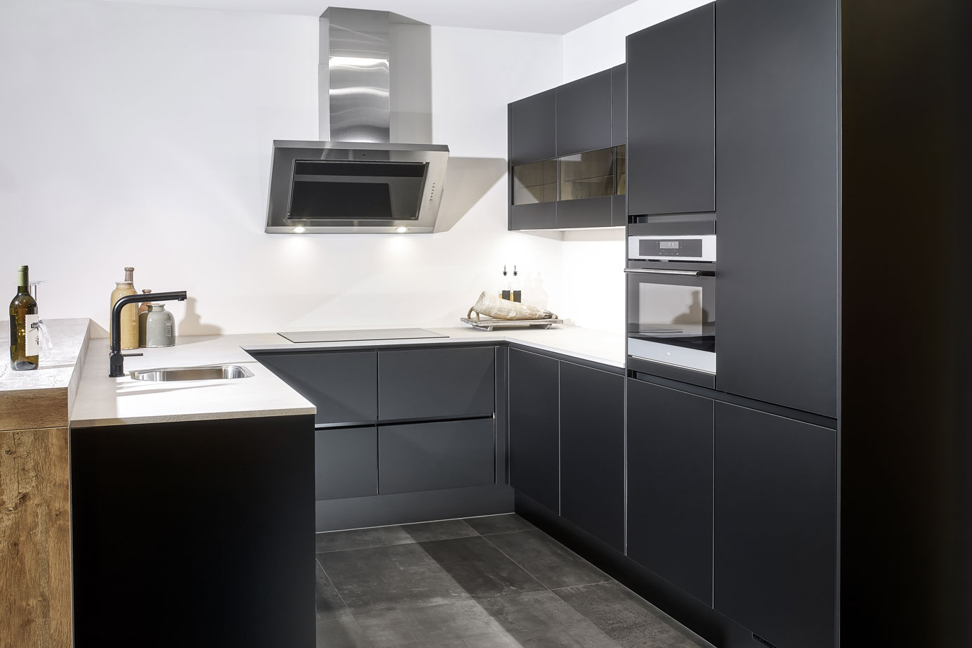 Deze zwarte moderne u-keuken heeft een bar in houtlook