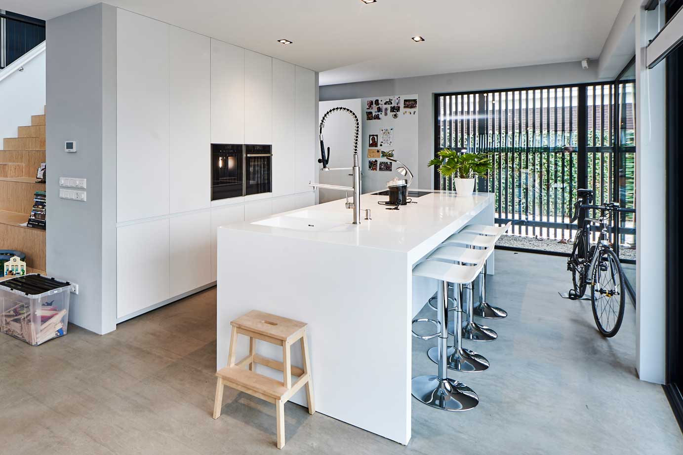 Witte chique keuken met eiland, bar en kastenwand