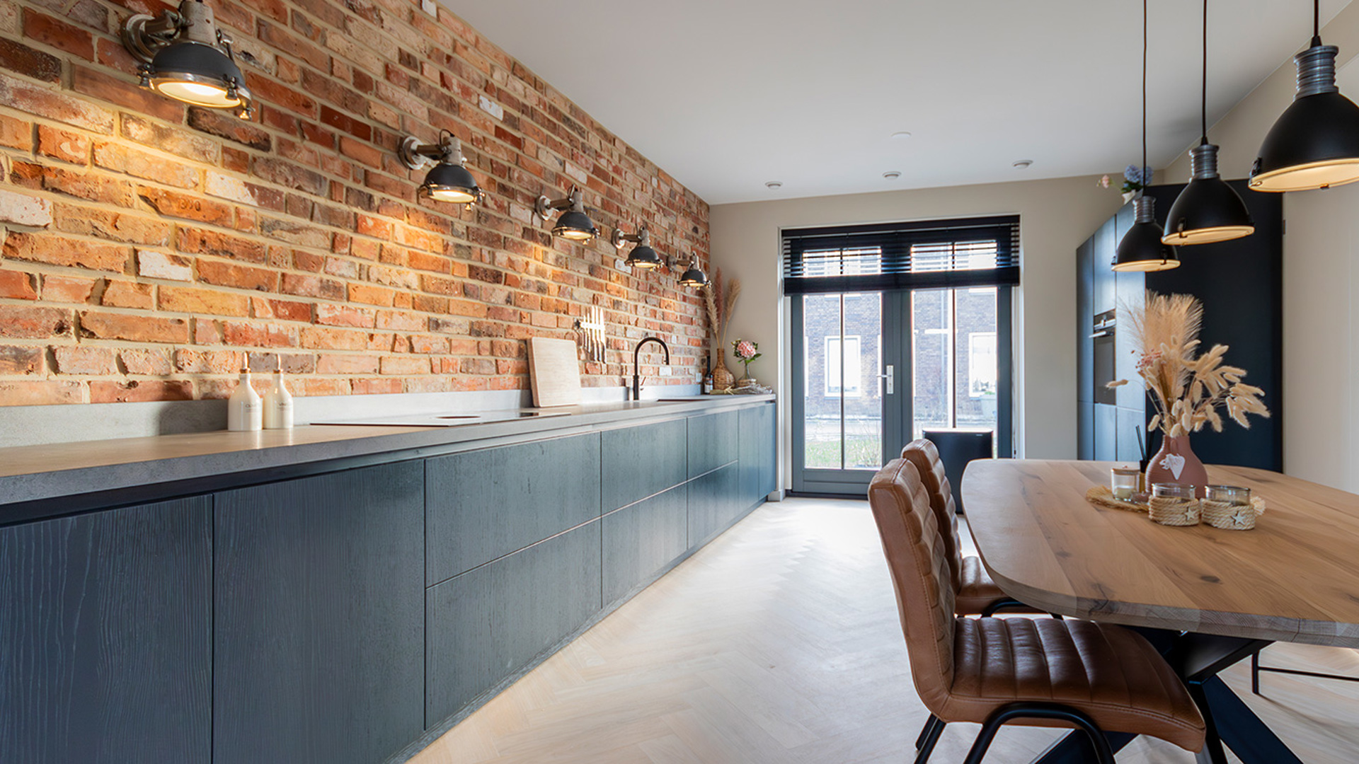 Compleet overzicht keuken, koelkast en eethoek met uitkijk op de tuin door groot raam 2