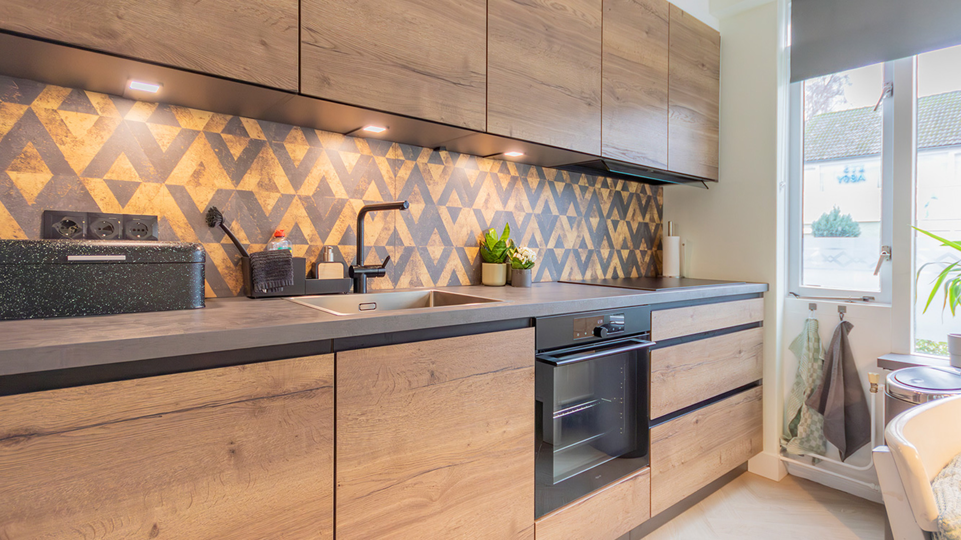 Een compleet overzicht van een rechte houten keuken. Foto is genomen vanuit een linkse hoek