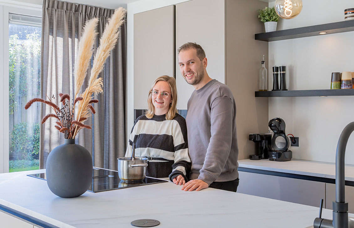 Moderne keuken met beige kasten, zwarte planken met koffie kopjes