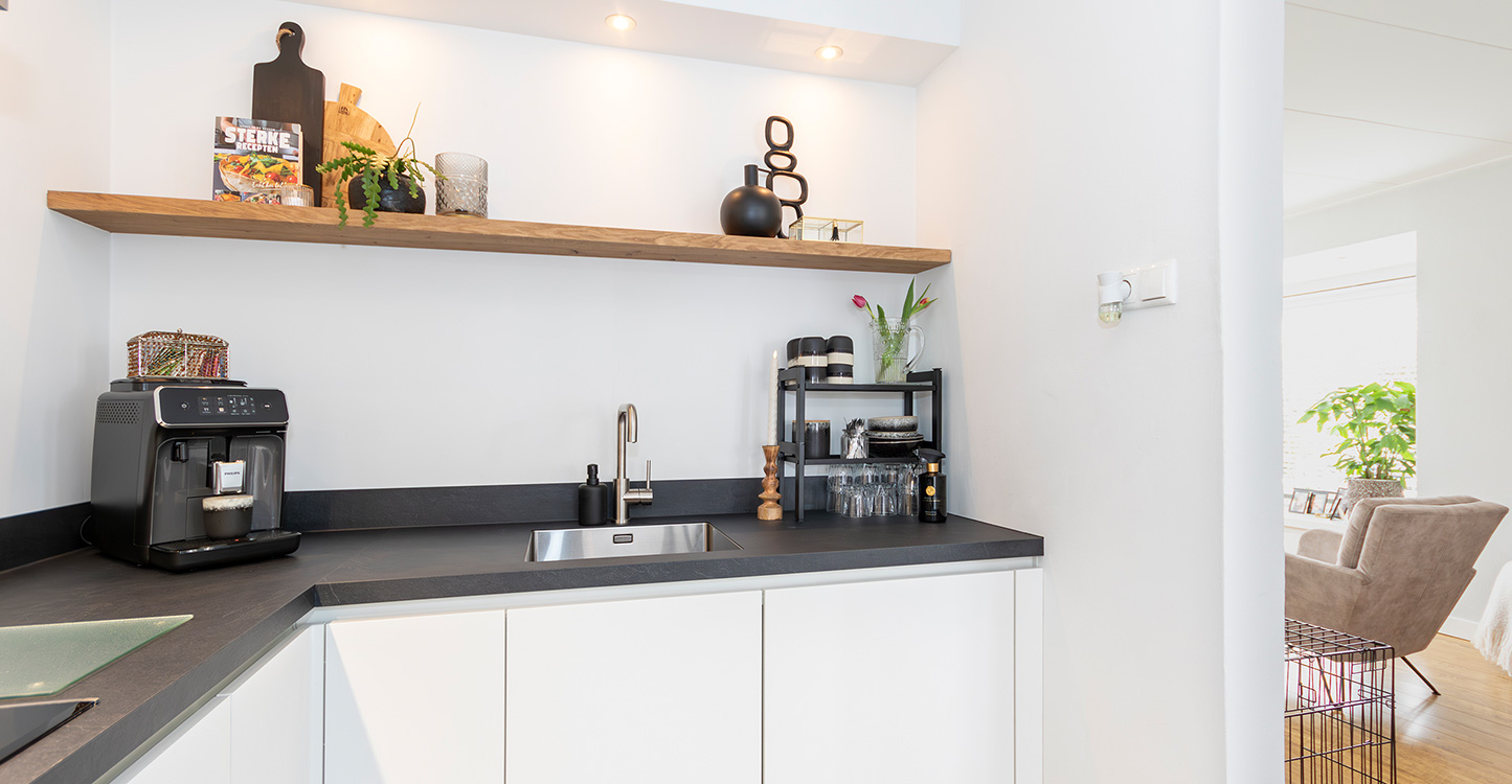 Witte hoekkeuken met zwart werkblad